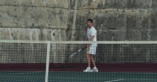 一个年轻的白种女人和一个年轻的白种男子在球场上打网球的正面视图 男子服务 — 图库视频影像