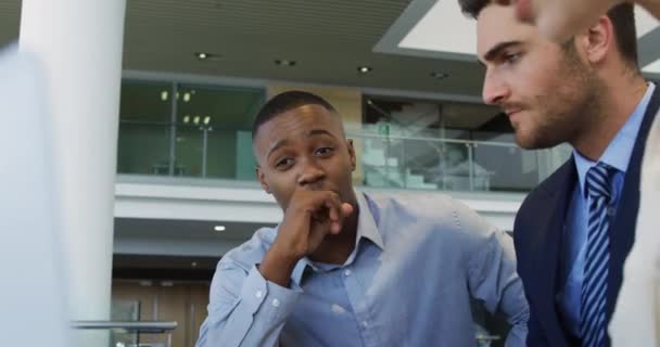 一位年轻的非洲裔美国商人坐在办公桌前 与一位年轻的白人商人和女商人在一个现代办公室的会议上交谈 — 图库视频影像