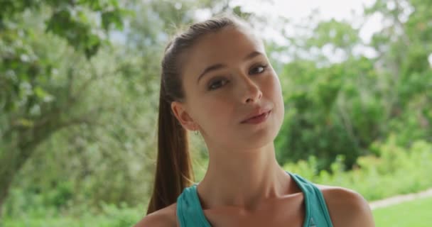 スポーツ服を着て庭のカメラに微笑む若い白人女性の肖像画 — ストック動画