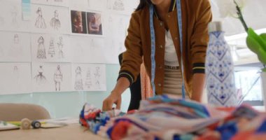 Moda tasarımları için kumaş seçimi, modern bir ofiste çalışan mutlu bir genç karışık ırk kadın iş yaratıcı Ön görünümü