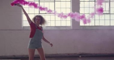 Boş bir depoda bir kalça genç Kafkas kadın yan görünümü, etrafında dönen ve bir el bombası tutan