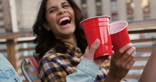 一个快乐的白种人和混血的年轻女性朋友在屋顶上的一个派对上 一边喝酒 一边笑 一边看近景 — 图库视频影像