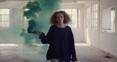 Boş bir depoda bir kalça genç Kafkas kadın ön görünümü, bir el bombası tutan