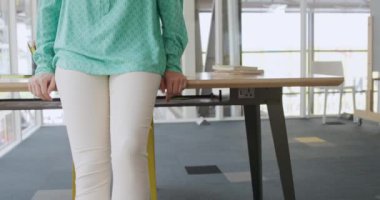 Modern bir ofiste çalışan, kameraya gülümseyen mutlu, genç, beyaz kadın iş kadınının portresi.