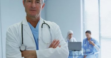 Hastanede kolları çapraz duran Beyaz erkek doktorun yakın çekim. O gülümsüyor ve kamera, video bakıyor  