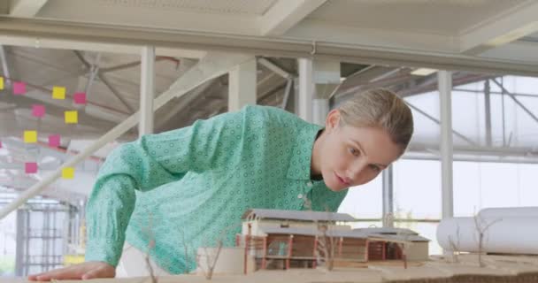 現代的なオフィスで働く幸せな若い白人女性のビジネス創造的な仕事のフロントビュー 3D建築モデルをチェック — ストック動画