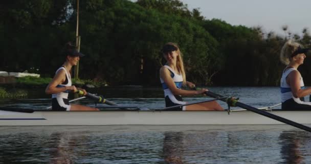 在河上划船训练时 四个年轻的成年白种妇女穿着赛车壳的侧视图 — 图库视频影像