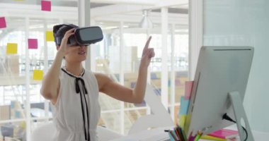 Modern bir ofiste çalışan mutlu bir genç karışık ırk kadın iş yaratıcı Ön görünümü, bir Vr kulaklık ve sanal bir ekran dokunmadan