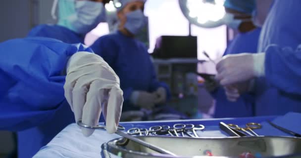 Cirujanos Multiétnicos Realizando Cirugía Quirófano Hospital Están Sosteniendo Instrumentos Quirúrgicos — Vídeo de stock