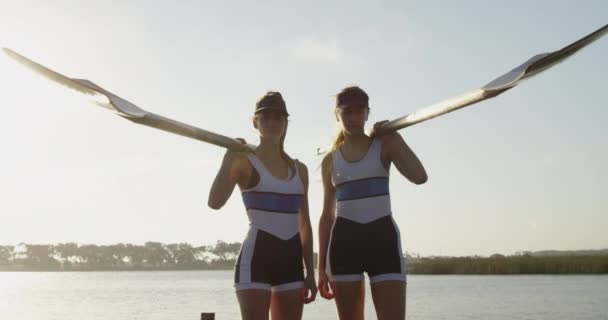 两个年轻的成年白种女划船手站在码头上 肩上挂着桨的肖像 — 图库视频影像