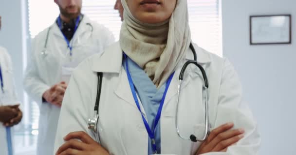 中东女医生站在医院 双臂交叉前视图 她微笑着看着相机 — 图库视频影像