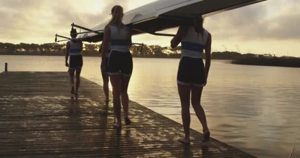 在河上训练之前 一支由四名年轻的成年白种人划船手组成的队伍 肩上扛着赛车壳 — 图库视频影像