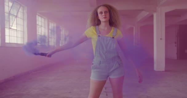 手榴弾を持った空の倉庫で腰の若い白人女性の正面図 — ストック動画