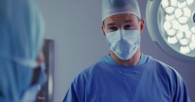 Hastanede operasyon tiyatrosunda ameliyat yapan çok ırklı cerrahların yakın çekim, video ,