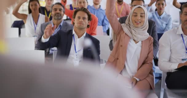 在一个商业研讨会上 大家都举起手 在舞台上向演讲者提问 站在不同的听众的肩膀上 — 图库视频影像