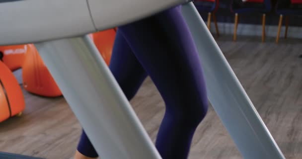 一个年轻的白种妇女在跑步机上跑步的侧视图特写 — 图库视频影像