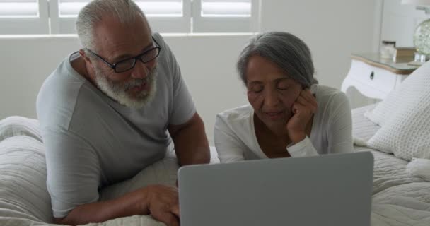 집에서 자신의 침실에서 노트북 컴퓨터를 사용하여 성숙한 커플의 전면보기 클로즈업 — 비디오