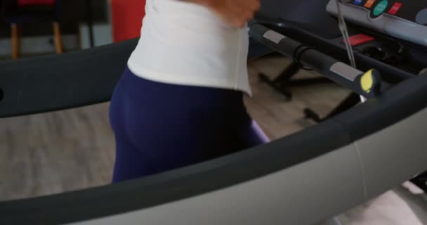 トレッドミルで走り トレーニング中に代謝ガス分析器を使用した若い白人女性の中間部分の側面図 — ストック動画