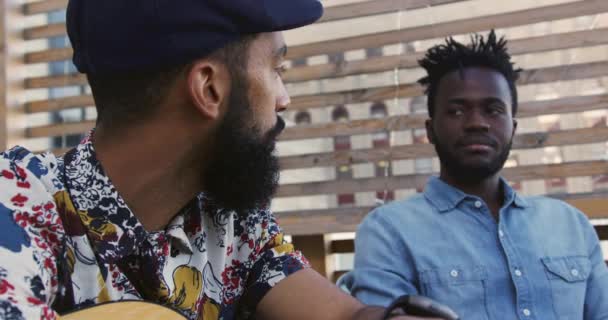 Vista Lateral Perto Jovem Mestiço Feliz Segurando Uma Guitarra Conversando — Vídeo de Stock