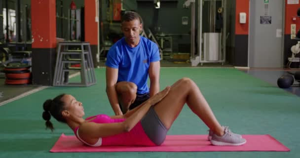 Vista Lateral Una Joven Mestiza Ejercitándose Gimnasio Con Joven Mestizo — Vídeo de stock