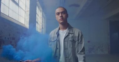 Boş bir depoda bir kalça genç karışık ırk adam Ön görünümü, bir el bombası ile yürüyüş