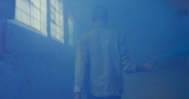 Boş bir depoda bir kalça genç karışık Yarış adam Arka görünümü, bir el bombası ile yürüyüş