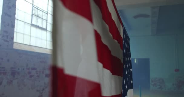空の倉庫でヒップ若い混合レースの男の側面図 青い煙でアメリカの旗を保持し — ストック動画