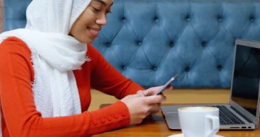 Gülümseyen kadın kafeteryada 4 k istimal hareket eden telefon