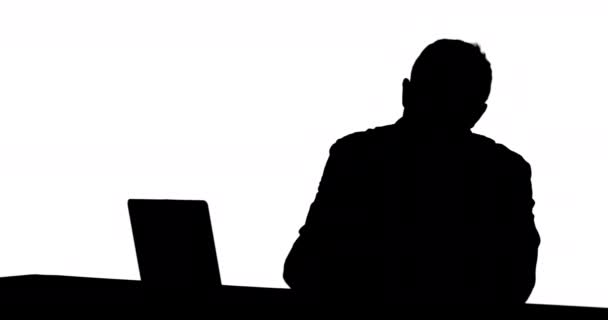 使用笔记本电脑的男子的正面视图 白色背景上的黑色剪影 — 图库视频影像