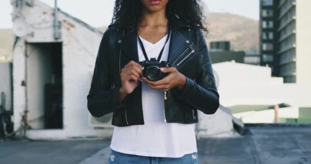 一个时髦的年轻混血女人在城市屋顶上拿着相机 背景是建筑物的正面视图 — 图库视频影像