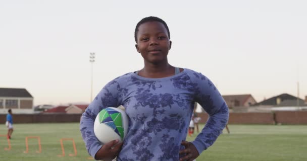 Porträtt Ung Vuxen Afroamerikansk Kvinnlig Rugbyspelare Stående Idrottsplan Med Rugbyboll — Stockvideo