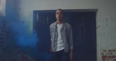 Boş bir depoda bir kalça genç karışık ırk adam Ön görünümü, bir el bombası ile yürüyüş