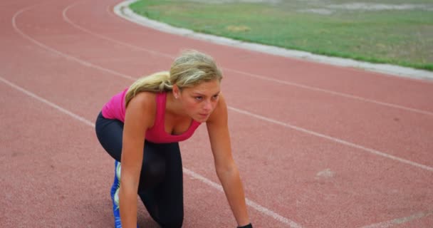 Front View Caucasian Female Athlete Taking Starting Position Running Track — Stockvideo