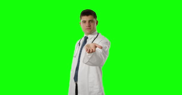 若い白人男性医師の正面図は 彼の手を差し出し 手のひらを上げてカメラに微笑み グリーンスクリーン — ストック動画