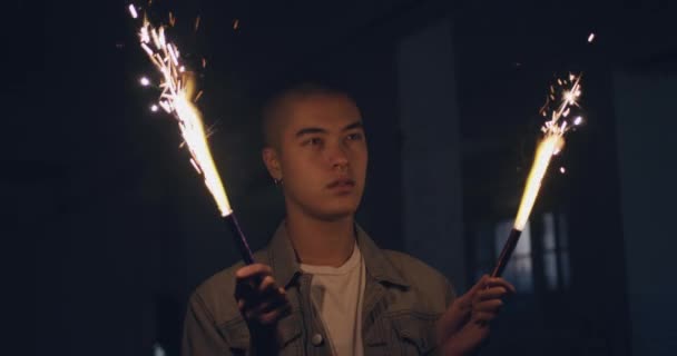 前视图特写一个时髦的年轻混血儿男子在一个空的仓库 举行火花 — 图库视频影像