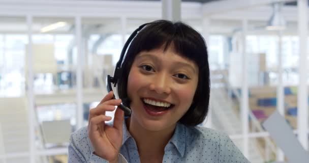 一个年轻的混血女性商业创意在现代办公室工作的肖像 使用耳机 说话和微笑的相机 — 图库视频影像