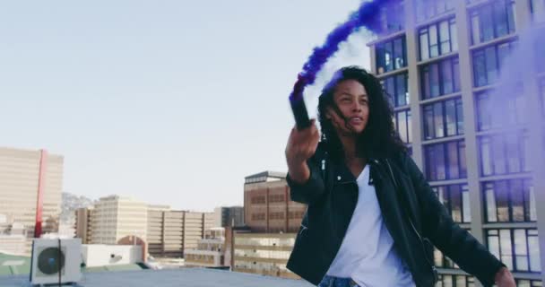 ヒップ若い混合人種の女性の正面図は 背景に建物と都市の屋上で笑顔と煙の手榴弾を使用しています — ストック動画
