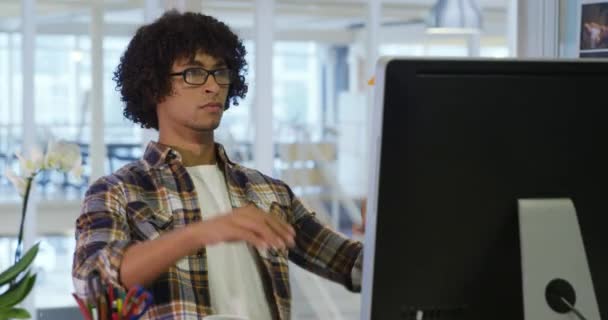 コンピュータとスマートフォンを使って現代のオフィスで働く若い男女ビジネスクリエイティブの正面図 — ストック動画
