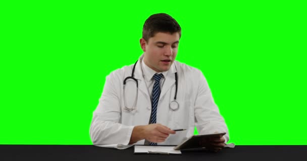 Vista Frontal Joven Médico Caucásico Usando Una Tableta Hablando Escribiendo — Vídeos de Stock