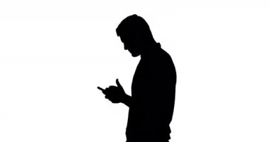 Akıllı telefon kullanan ve beyaz arka planda gülümseyen siyah siluet kullanan bir adamın yan görünümü
