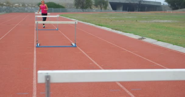 Atleta Feminina Caucasiana Correndo Sobre Obstáculos Uma Pista Corrida Local — Vídeo de Stock