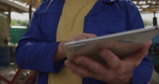 タブレットコンピュータを使用して 有機農場で成熟した白人男性農家の正面図クローズアップ — ストック動画