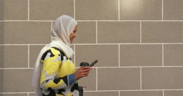 카메라에 스마트 사용하여 거리에서 히잡을 여성의 측면보기 — 비디오