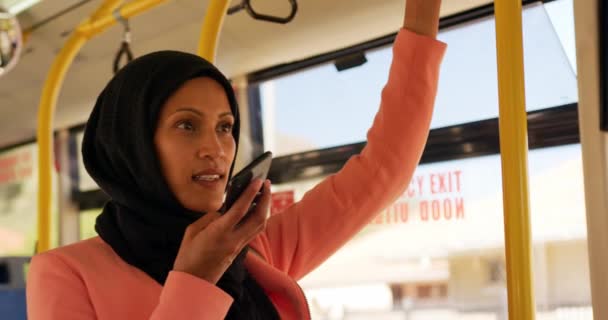 도시에서 버스에서 통근하는 히잡을 스마트 폰으로 이야기하는 여성의 — 비디오