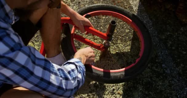 Visão Aérea Seção Baixa Jovem Caucasiano Reparando Roda Sua Bicicleta — Vídeo de Stock