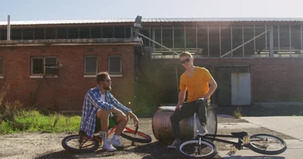 Framsidan Två Unga Kaukasiska Män Bär Solglasögon Sitter Med Bmx — Stockvideo