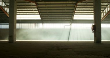 Güneş ışığında terk edilmiş bir depo içi duman bombasıyla dolu.