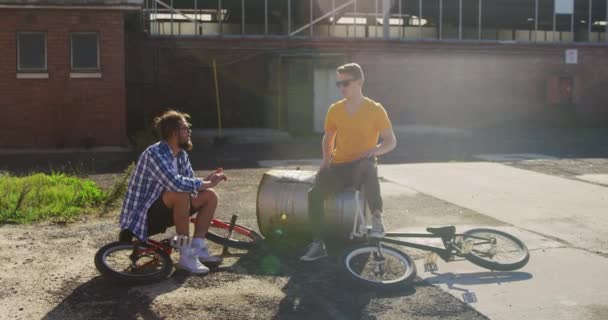 Framsidan Två Unga Kaukasiska Män Bär Solglasögon Sitter Med Bmx — Stockvideo