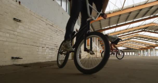 Vista Frontal Dos Jóvenes Caucásicos Montados Bicicleta Bmx Almacén Abandonado — Vídeo de stock