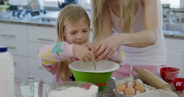 圣诞节时 一个快乐的年轻白种人母亲带着小女儿在厨房里 做饼干 把鸡蛋打进搅拌碗里 面带微笑 — 图库视频影像